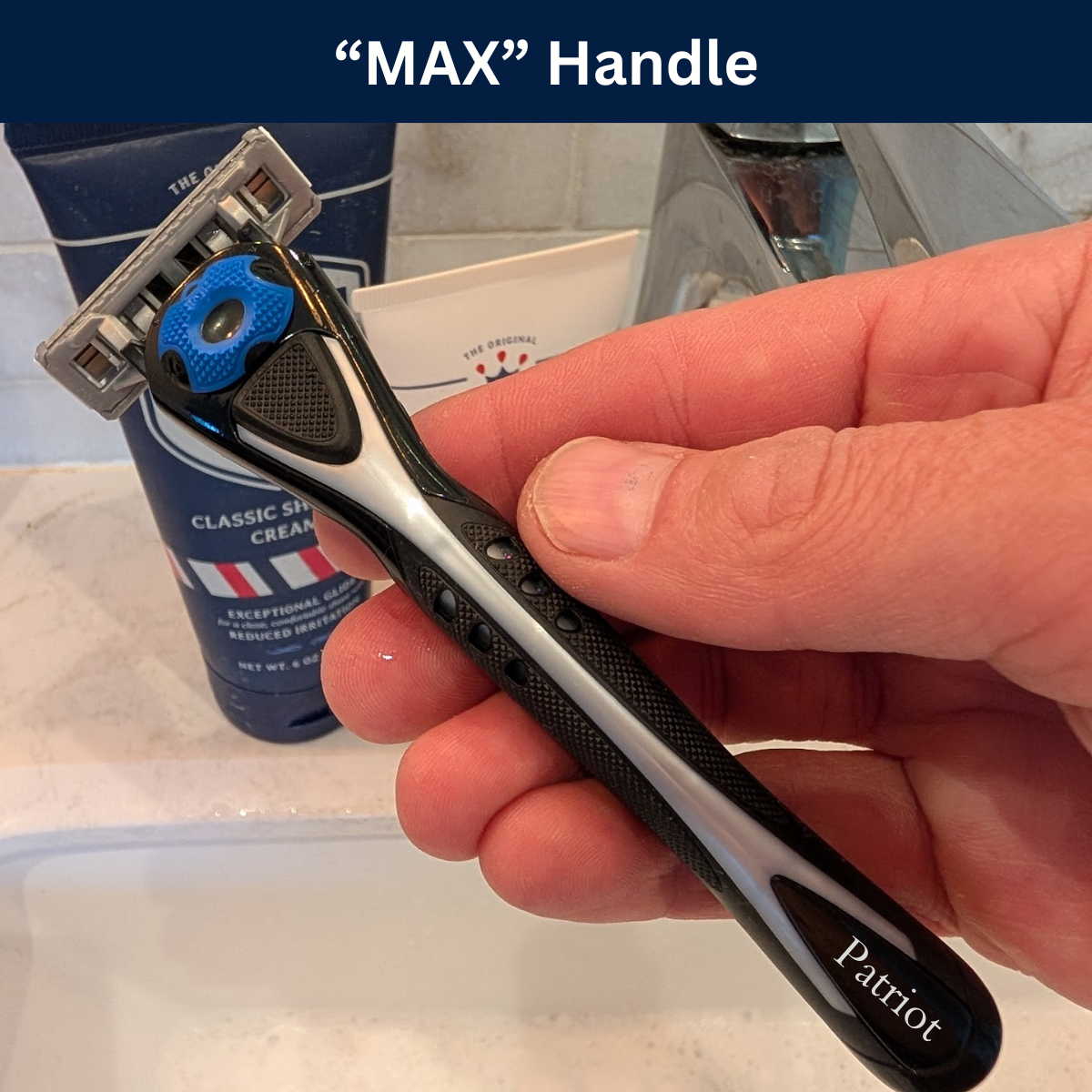 Hand holding a Patriot Shave MAX Handle razor with shaving cream and razor in the background.