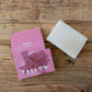 Bar of soap and pink packaging on a wooden surface