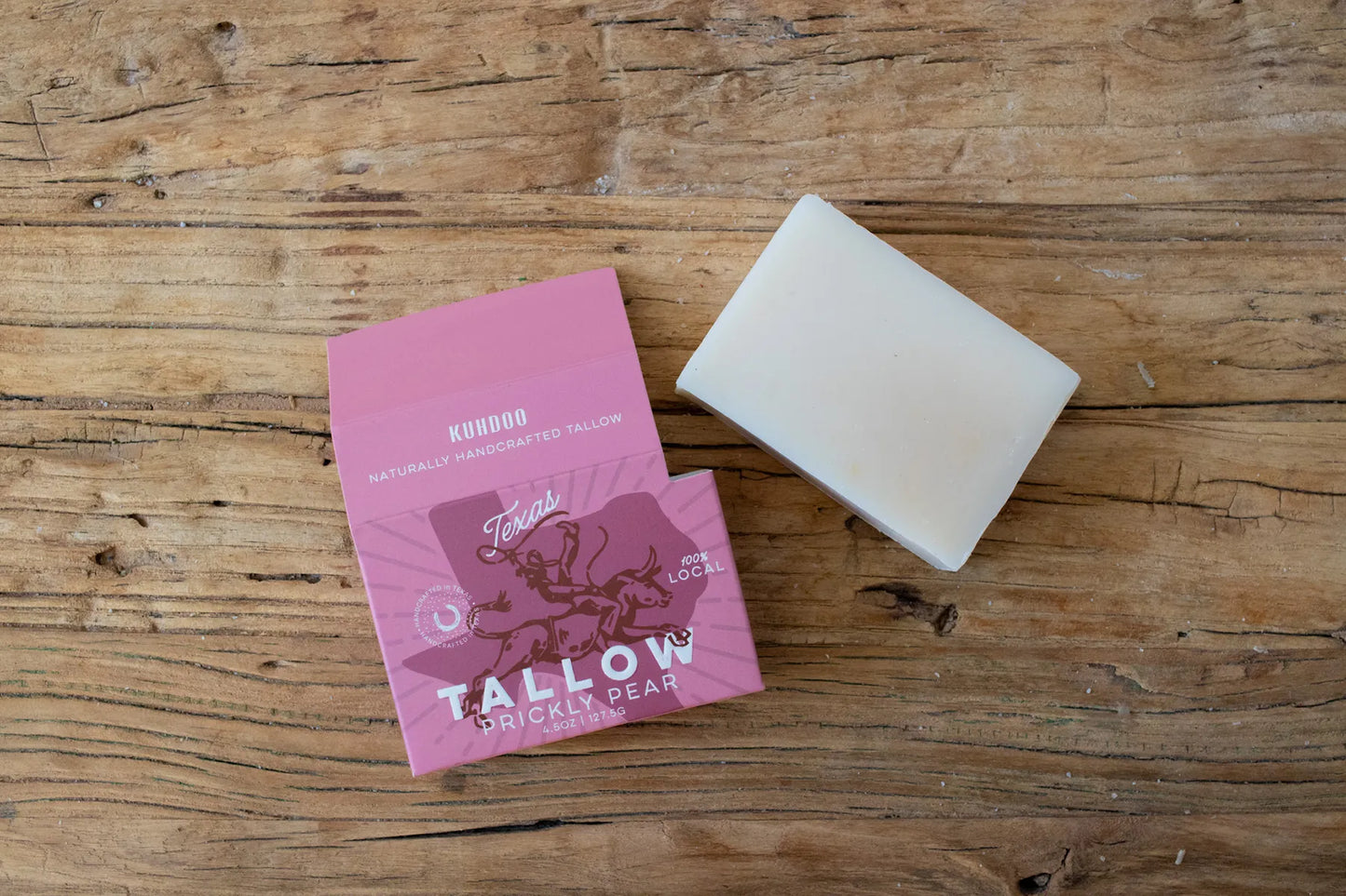 Bar of soap and pink packaging on a wooden surface