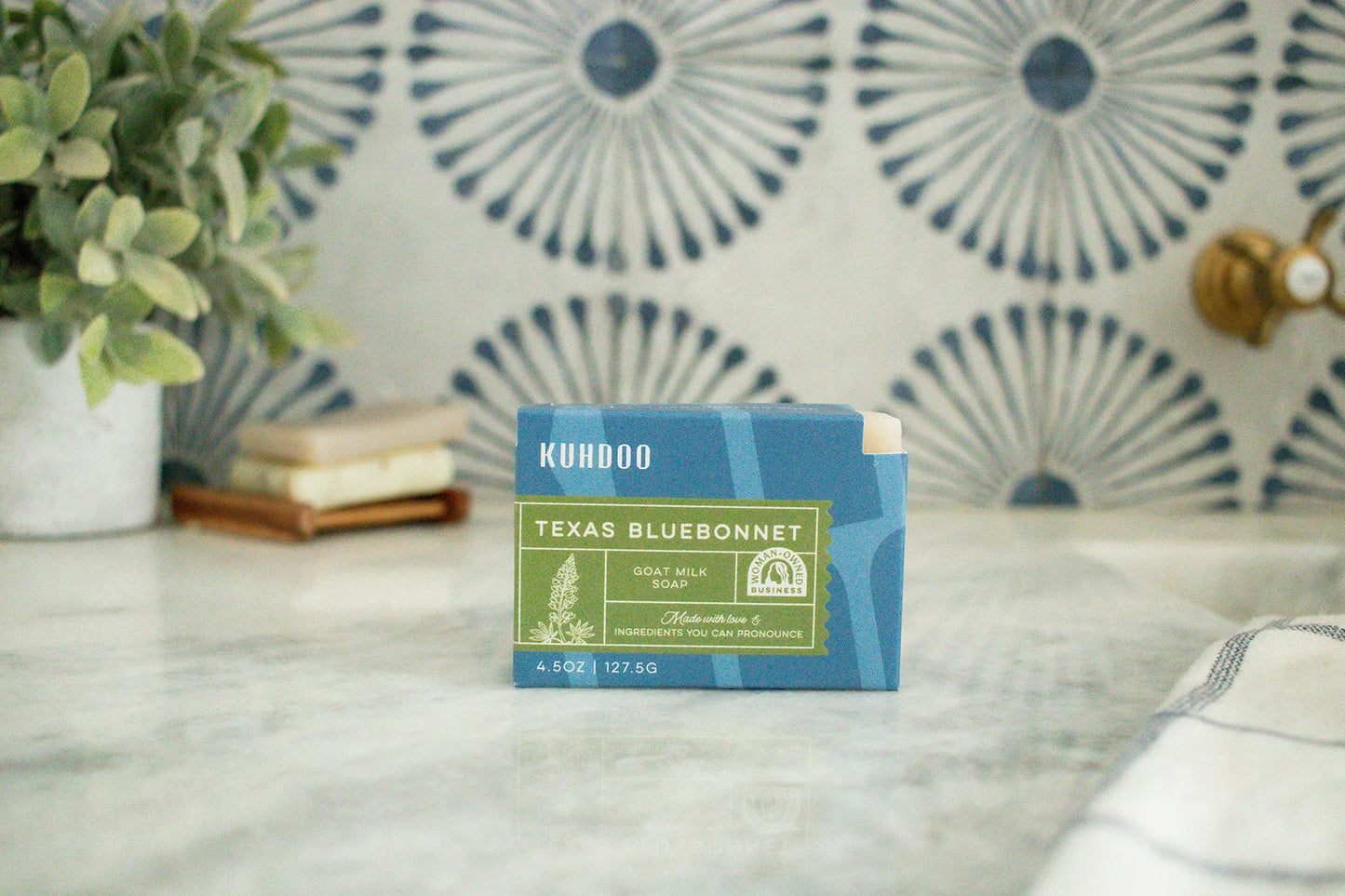 Kuhdoo Texas Bluebonnet soap bar on a marble surface with decorative tiles in the background